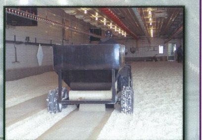 A Feed Caddy laying paper and feed down the length of a poultry barn